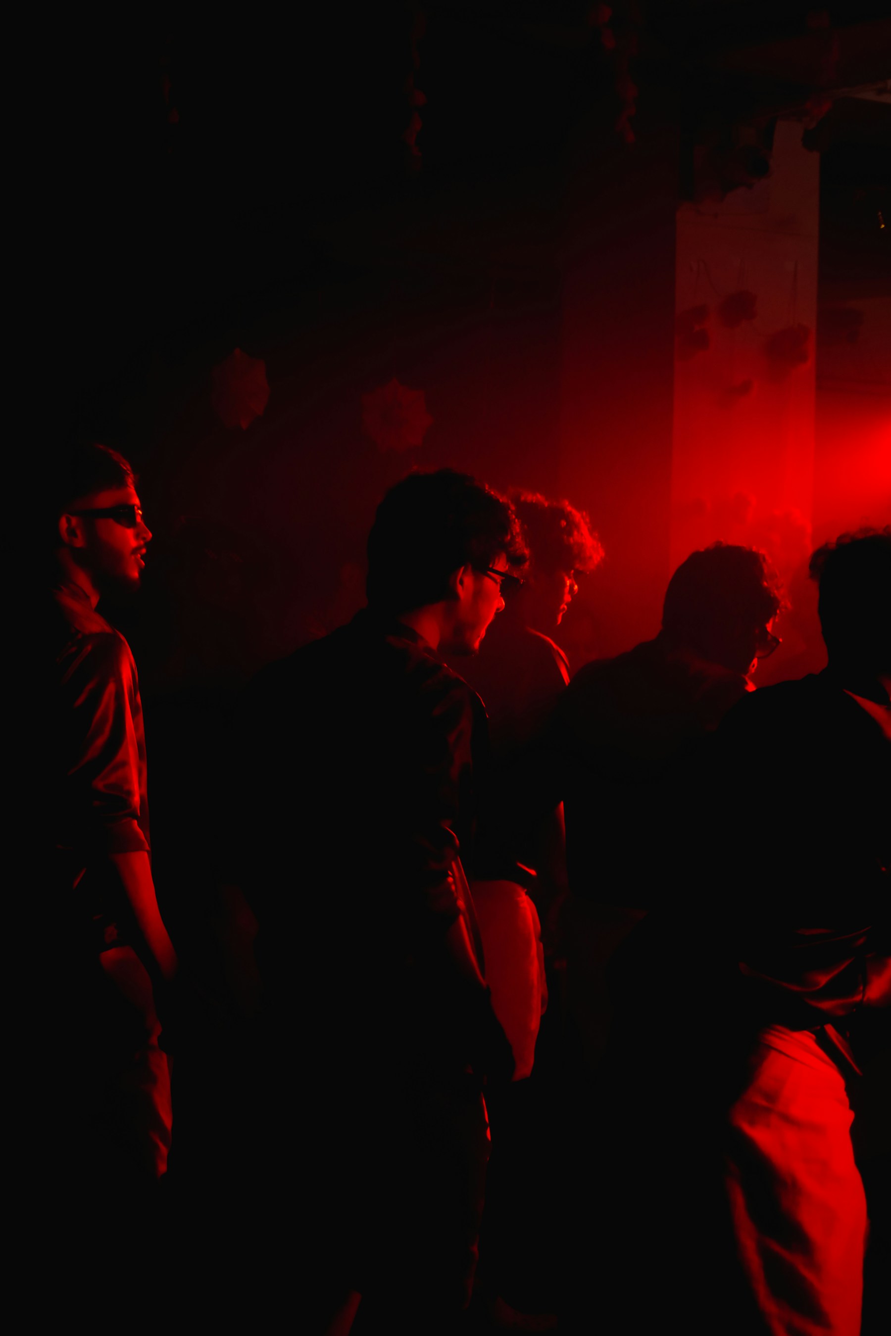 Friends together in a dark music room under red light
