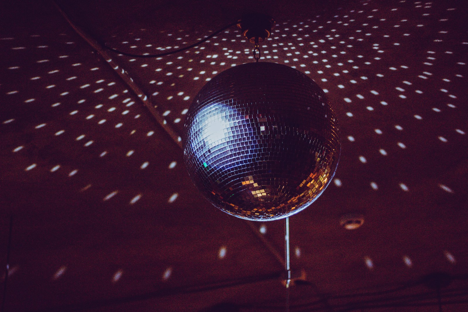 A silver disco ball catching the light in a dark room